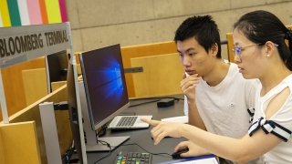 Ruiqi Yang collaborates with his professor as he looks at data on a computer. 