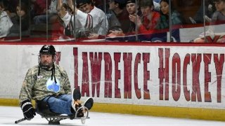 Randy Gollinger, a member of the Mountain Warriors sled hockey team, takes a lap Friday night around the ice before a trophy presentation honoring Joe Marsh for his work with the organization.