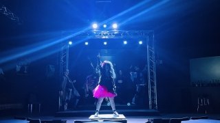 Photo of Woman in Pink Skirt playing air guitar