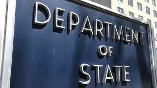 Close-up of the sign outside the State Department, which reads "Department of State" in large sans-serif silver letters in all caps.