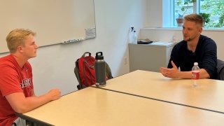 two men sitting at a table having a discussion
