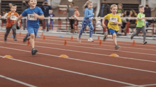 Image of children running inside St. Lawrence University Newell Field House racing to earn the title of "Fastest Kid."