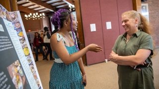 Sarath Novas discusses her research presentation with Professor Sara Ashpole.