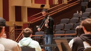 Jake Blount plays the violin to a group of students.