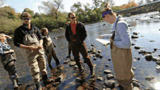 Photo of Brad Baldwin, Conservation Biologist in the field with students performing research.