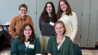 female professor with her four female students posing for picture