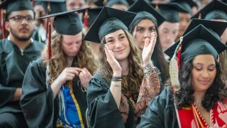 Photo of students sitting in audience clapping with smiling faces and happy expressions as they watch the commencment 2024 ceremony.