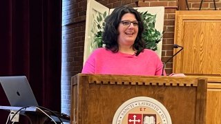 woman wearing pink sweater smiling on podium