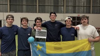 ATO members holding their chapter flag at their annual dodgeball philanthropy event