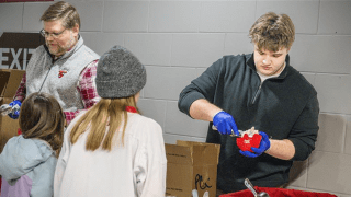 Connor Simons '28 serving scoops of Pub Cookie Crunch to local hockey fans at the Route 11 Rivalry game