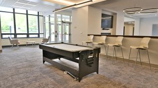The spacious lobby of Whitman Hall including multiple seating areas and a pool table.