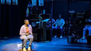 Image of black woman on stage in spotlight