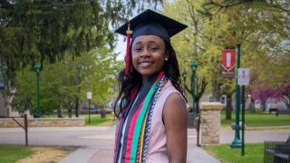Class of 2026 grad Francesca Mnenula poses on campus accessorized in graduation cap and cords 