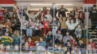 A crowd of cheering children in Appleton Arena cheer on the Saints Women's Ice Hockey Team