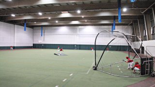 Interior of Leithead Field House featuring students practicing baseball