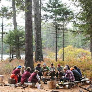 Students outside in the woods taking a class