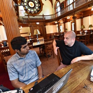Student and faculty member talking at desk