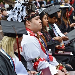 Commencement including Native American in traditional clothing
