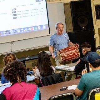 Faculty member playing drum