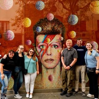 Laurentians in front of painting of David Bowie