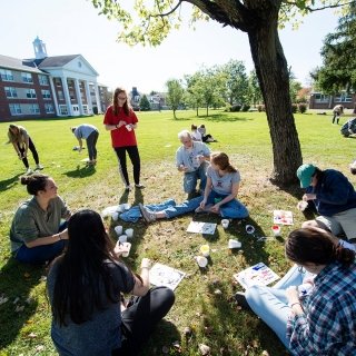 Students working outdoors with faculty member