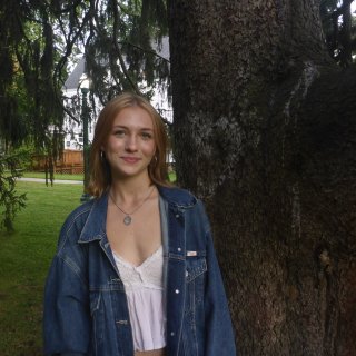Annie on campus in front of a tree