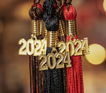 Three brown, black, and scarlet graduation tassels with gold 2024 emblems. 