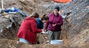 Faculty member and students doing field work