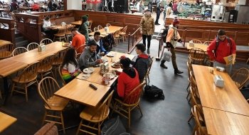A group of Saint Lawrence students engaged in animated discussion at a large rectangular dining table. Photo from January 2020.