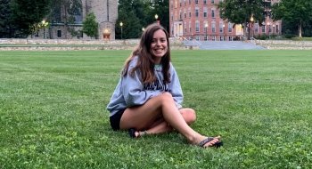 A Saint Lawrence student sits on the quad on a quiet night on campus.