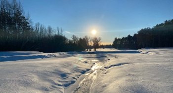 The sun rises over a snow-covered golf course on the Saint Lawrence University campus.