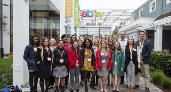 A group of 20 Saint Lawrence students stand with alumni in front of ebay.