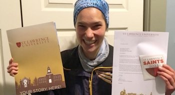 Meg Charles, holding a Saint Lawrence acceptance folder and letter.