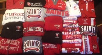 Scarlet, grey, and brown Saint Lawrence sweatshirts and jackets on a table.