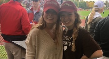 Abbie Cooper and Abby Eberle, wearing red Saint Lawrence hats, attend a football game.