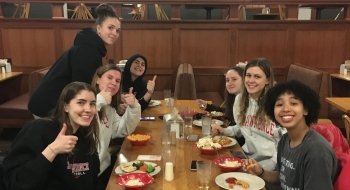 A group of Saint Lawrence students sit at a table and have a meal together.