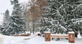 The Saint Lawrence University entrance sign on a snowy winter day.
