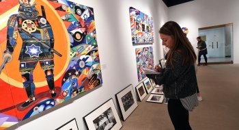 student examining artwork in the gallery