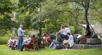 A small class sits outside and listens intently to professor Howard Eissenstat.