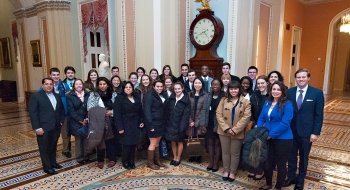 A group of Saint Lawrence University students, wearing business professional attend an alumni event in Washington, D.C. attire,