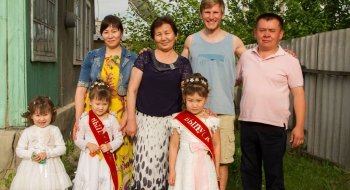 A Saint Lawrence University students stands with his host family abroad.