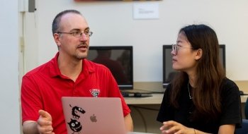 Saint Lawrence University professor Ivan Ramler, wearing a red polo, talks about an assignment with a student.