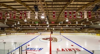 Banners hang from the rafters above the Saint Lawrence Hockey emblem on the ice of Appleton Arena.