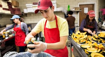 Saint Lawrence University students prepare a meal in a kitchen.