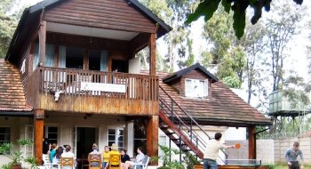 Several Saint Lawrence students sit outside and play games, on a sunny day, at the Kenya campus during the Kenya Semester Program.