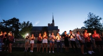 a group of people standing before a chapel