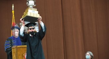 A student raises up a trophy during the Commencement celebrations for the class of 2021