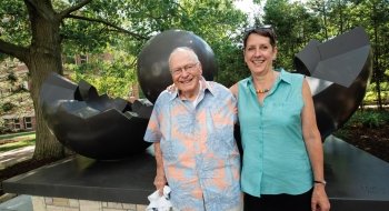 Dick Brush '52 with Cathy Tedford in front of the sculpture BirthIV