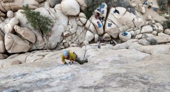 A photo of students scaling the side of a rocky cliff.