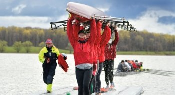 students holding a rowing eight above their heads